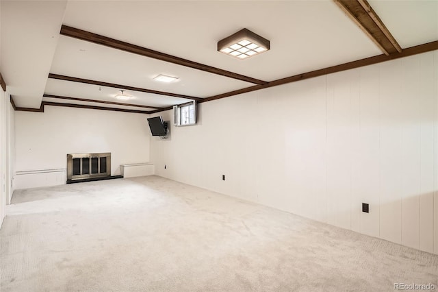 below grade area featuring a glass covered fireplace and carpet flooring