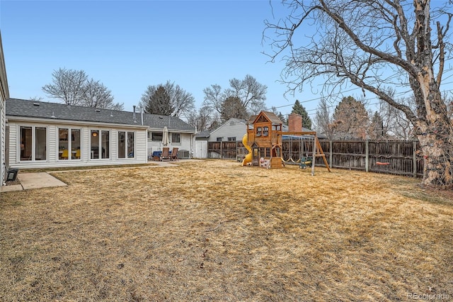 view of yard featuring a playground, a patio area, a fenced backyard, and central air condition unit