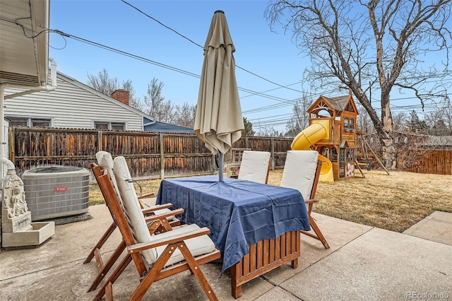 view of patio with a playground, a fenced backyard, and central air condition unit