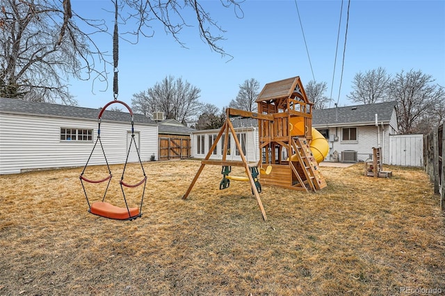 view of jungle gym with a lawn, cooling unit, and a fenced backyard