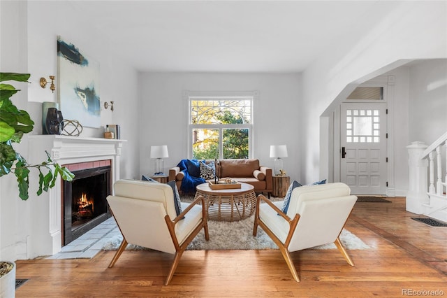 living room with a fireplace and light wood-type flooring