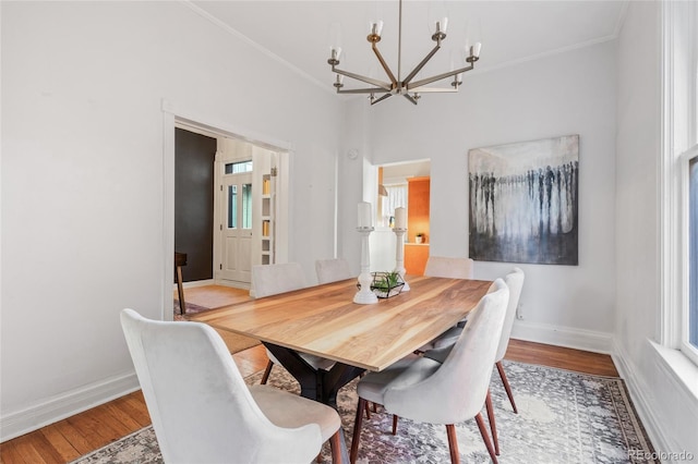 dining room with crown molding, hardwood / wood-style flooring, and a notable chandelier