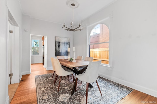 dining area featuring light hardwood / wood-style floors, a healthy amount of sunlight, and an inviting chandelier