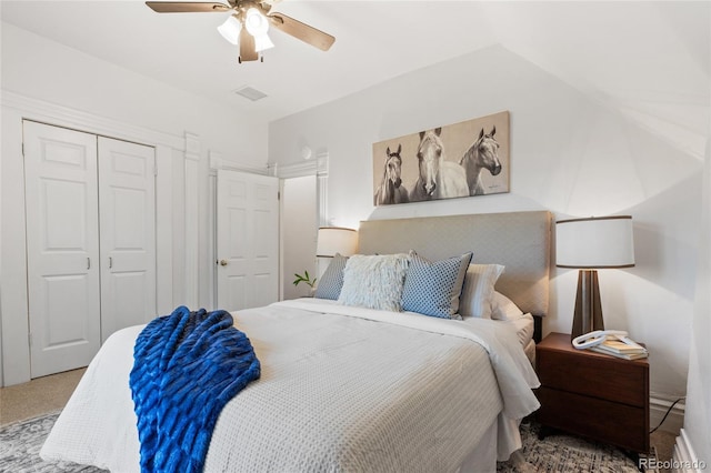 bedroom with a closet, carpet floors, vaulted ceiling, and ceiling fan