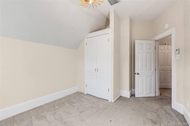 bonus room with vaulted ceiling and light colored carpet