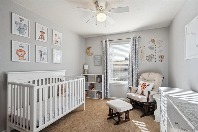 bedroom featuring ceiling fan, carpet flooring, and a nursery area