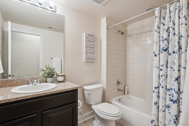 full bathroom featuring toilet, vanity, shower / bath combo with shower curtain, and a textured ceiling