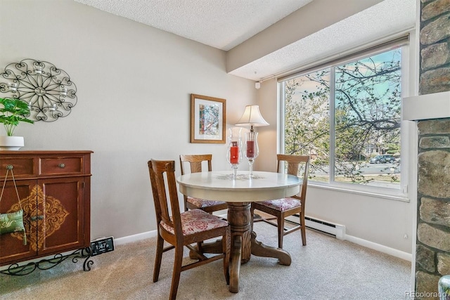 dining area featuring light carpet, a textured ceiling, plenty of natural light, baseboards, and a baseboard heating unit