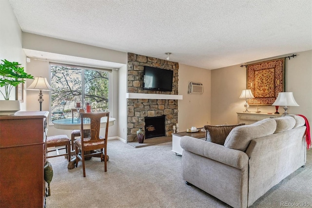 living area with a textured ceiling, light carpet, a wall mounted air conditioner, and a fireplace