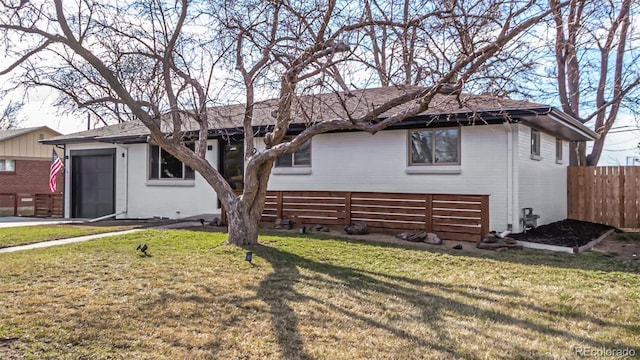 ranch-style house with brick siding, a garage, a front lawn, and fence