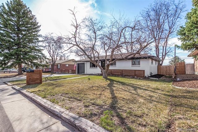 ranch-style home featuring stucco siding, a front lawn, a garage, and fence