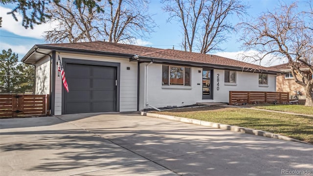 ranch-style home featuring roof with shingles, an attached garage, concrete driveway, a front lawn, and brick siding