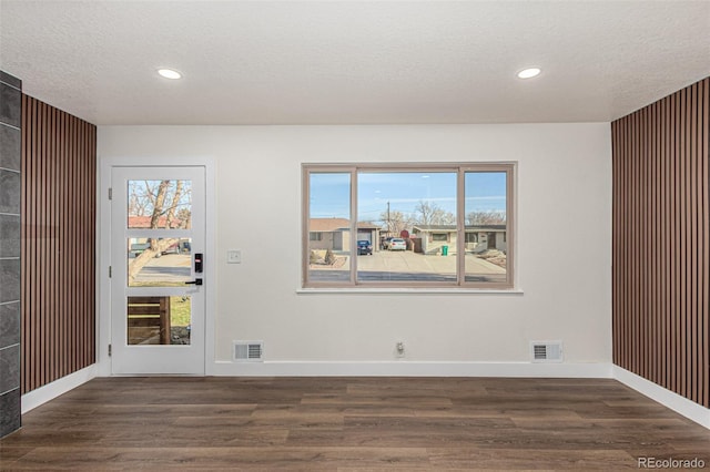 unfurnished room featuring recessed lighting, visible vents, a textured ceiling, and wood finished floors