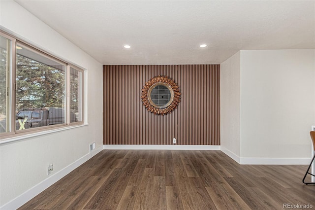 unfurnished room with visible vents, baseboards, and wood finished floors