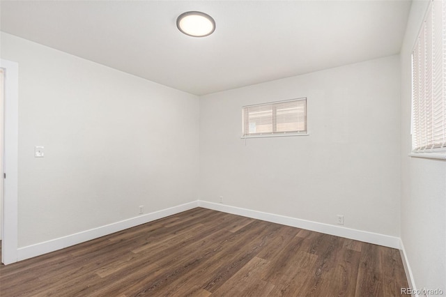 empty room with plenty of natural light, baseboards, and dark wood-style flooring