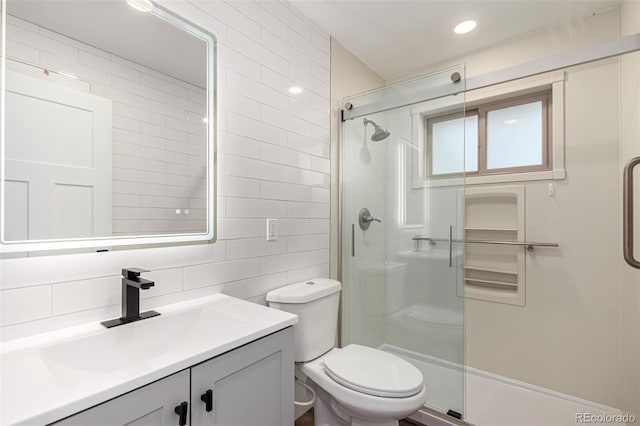 full bath with tasteful backsplash, toilet, vanity, a stall shower, and tile walls