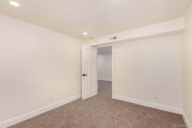 empty room featuring visible vents, light colored carpet, and baseboards