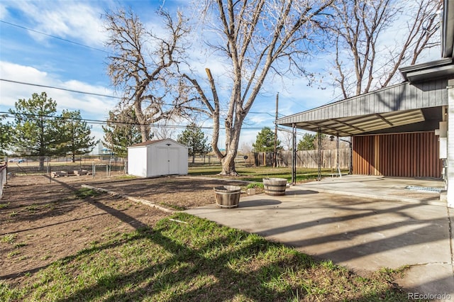 view of yard featuring an outbuilding, a storage shed, and fence