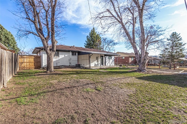 rear view of property with a yard and fence