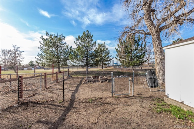 view of yard featuring a gate, a rural view, and fence