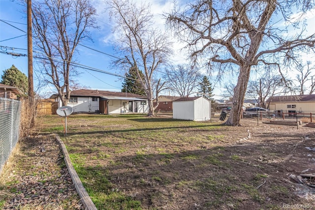 view of yard with an outbuilding, a storage shed, and a fenced backyard