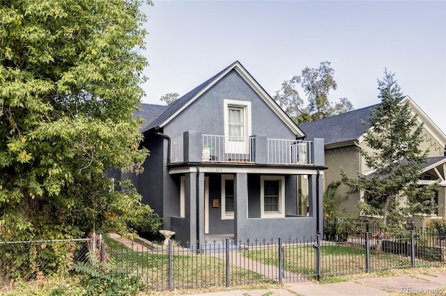 2731 California St, Denver, CO 80205 - view of front of home featuring a balcony, a fenced front yard, stucco siding, and covered porch