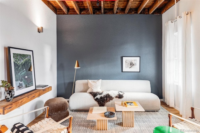 living area featuring hardwood / wood-style flooring, beam ceiling, and wooden ceiling