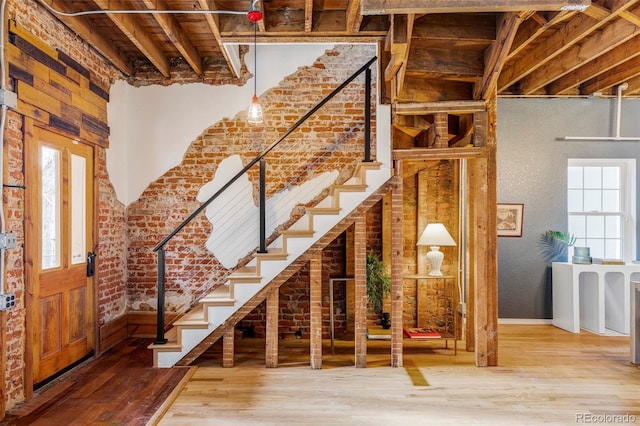 interior space with wood-type flooring and brick wall