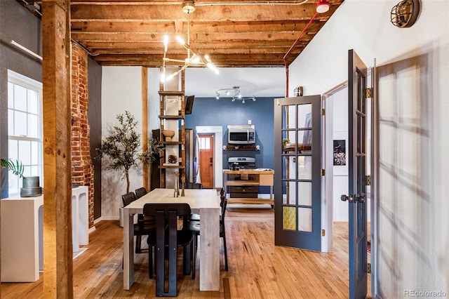 dining space featuring hardwood / wood-style flooring, beamed ceiling, and french doors