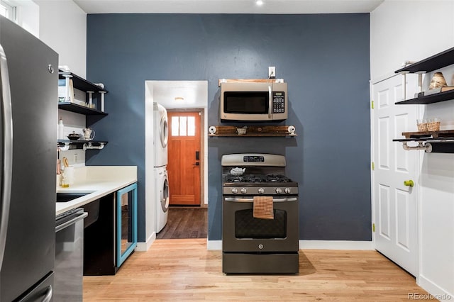 2731 California St, Denver, CO 80205 - kitchen with stainless steel appliances, open shelves, stacked washing machine and dryer, and beverage cooler