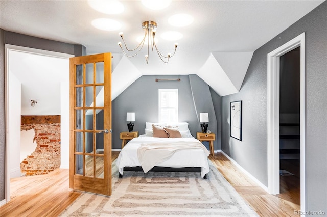 bedroom with hardwood / wood-style floors and lofted ceiling