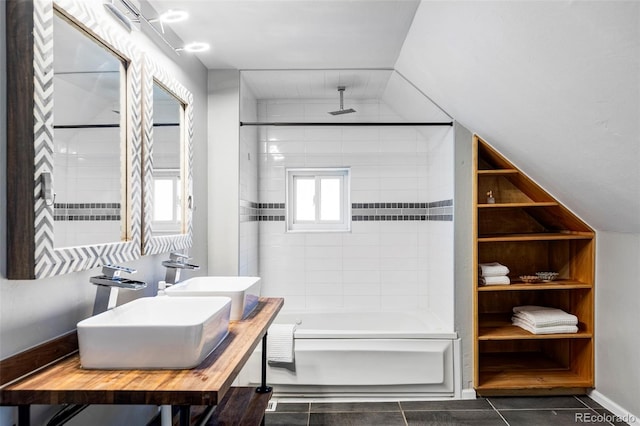 bathroom featuring tile patterned floors, sink, lofted ceiling, and tiled shower / bath