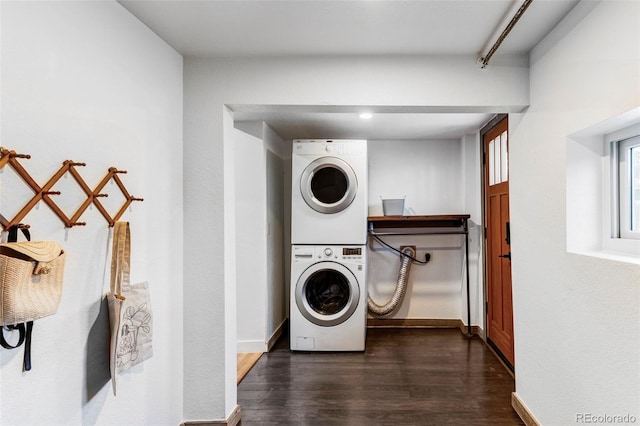 laundry area featuring dark wood-type flooring and stacked washer and clothes dryer