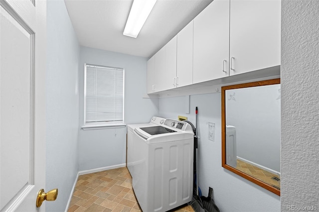 laundry area featuring washer / dryer, cabinet space, and baseboards