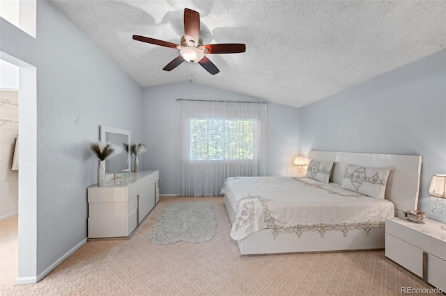 carpeted bedroom featuring lofted ceiling, a textured ceiling, ceiling fan, and baseboards