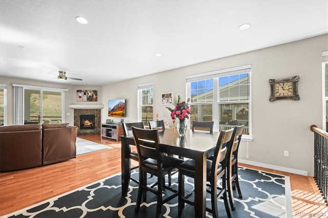 6174 Flattop St, Golden, CO 80403 - dining room with a lit fireplace, a ceiling fan, wood finished floors, healthy amount of natural light, and recessed lighting