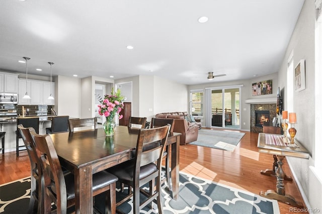 6174 Flattop St, Golden, CO 80403 - dining room with wood finished floors, a glass covered fireplace, ceiling fan, recessed lighting, and baseboards