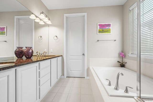 6174 Flattop St, Golden, CO 80403 - bathroom featuring a garden tub, double vanity, tile patterned flooring, and baseboards