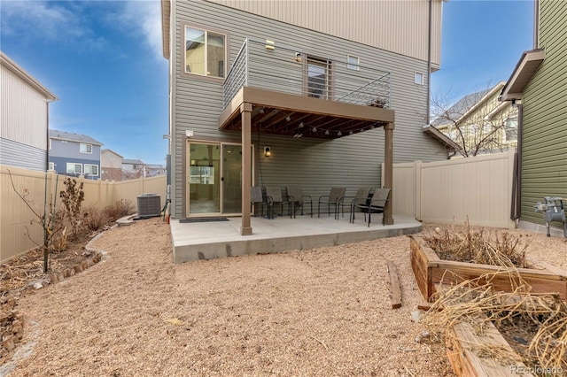 back of property with central air condition unit and a patio area