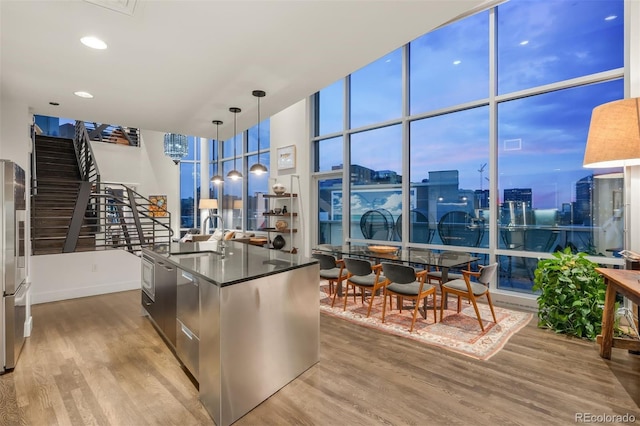 55 W 12th Ave Unit 608, Denver, CO 80204 - kitchen featuring wood finished floors, dark countertops, expansive windows, a city view, and high quality fridge