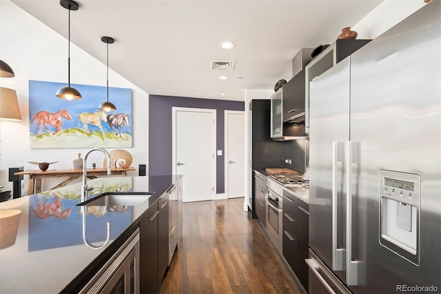 55 W 12th Ave Unit 608, Denver, CO 80204 - kitchen featuring appliances with stainless steel finishes, dark countertops, dark wood finished floors, modern cabinets, and decorative light fixtures
