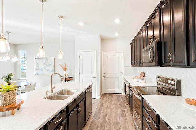 6041 N Orleans St, Aurora, CO 80019 - kitchen featuring stainless steel appliances, a sink, light countertops, hanging light fixtures, and decorative backsplash
