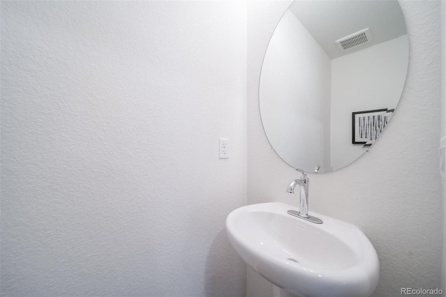 bathroom with visible vents and a sink