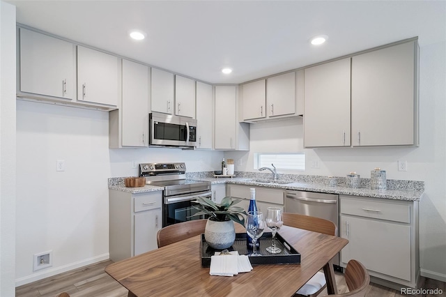 kitchen featuring recessed lighting, appliances with stainless steel finishes, light wood-style floors, and a sink