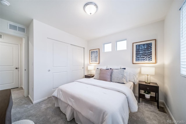 bedroom featuring visible vents, baseboards, a closet, and carpet flooring