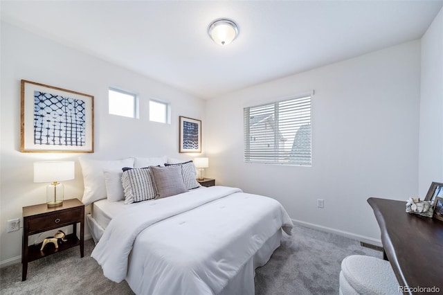 carpeted bedroom featuring multiple windows, visible vents, and baseboards