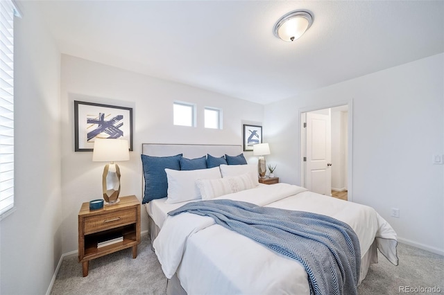 bedroom featuring baseboards and light carpet