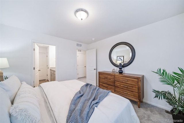 bedroom featuring visible vents, baseboards, light colored carpet, and ensuite bathroom