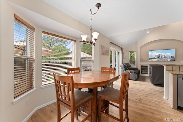1825 Cooper Ct, Castle Rock, CO 80109 - dining room featuring a chandelier, lofted ceiling, light wood-type flooring, baseboards, and a glass covered fireplace