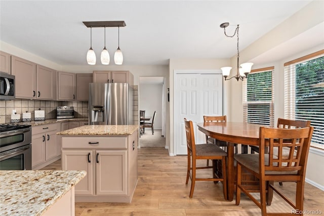 1825 Cooper Ct, Castle Rock, CO 80109 - kitchen featuring appliances with stainless steel finishes, a chandelier, light wood-type flooring, decorative backsplash, and pendant lighting